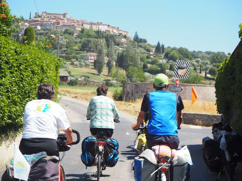 Cyclistes chargés et village à vue